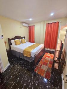 a bedroom with a bed and a red curtain at Beulah Luxury Suites in Georgetown