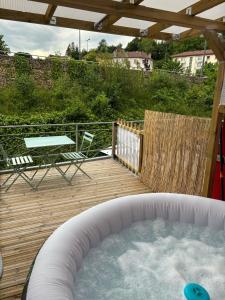 una vasca idromassaggio su una terrazza in legno con tavolo di Jacuzzi, 2min Gare, cosy work fun a Bellegarde-sur-Valserine
