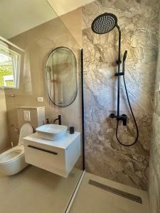 a bathroom with a shower and a sink and a toilet at Apartmani Andrea in Promajna