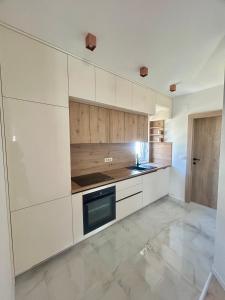 a kitchen with white cabinets and a stove at Apartmani Andrea in Promajna