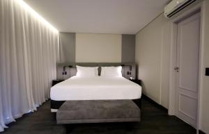 - une chambre avec un grand lit blanc et une fenêtre dans l'établissement Radisson Oscar Freire, à São Paulo