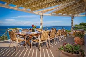 a table and chairs on a patio with the ocean at Il sogno di Zante in Skinária +125 photos