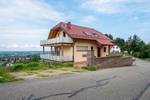 una casa con techo rojo en la cima de una colina en Haus am Bächel 2, en Obersasbach