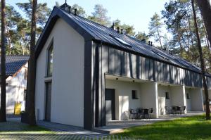 a large white building with black roof at Karłowy Las in Milicz