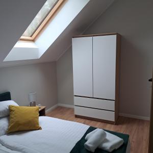 a bedroom with a white cabinet and a bed at Karłowy Las in Milicz