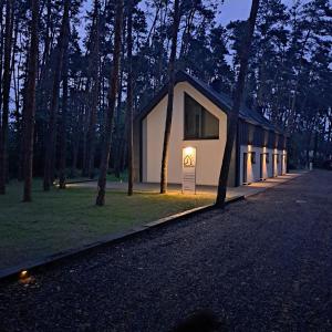 a building with a sign in the middle of a forest at Karłowy Las in Milicz