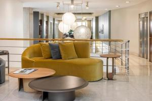 a living room with a yellow couch and tables at Argenta Tower Hotel & Suites in Buenos Aires