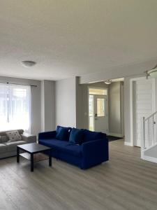ein Wohnzimmer mit einem blauen Sofa und einem Tisch in der Unterkunft Private room in Calgary*Netflix*TV*Wifi*Parking in Calgary