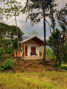 uma pequena casa no meio de um campo em Serenity Sinharaja em Deniyaya