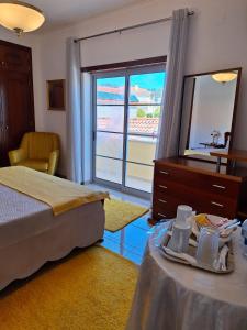 1 dormitorio con cama, tocador y espejo en Casa Branca Pinhal, en Nazaré