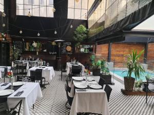 a restaurant with white tables and chairs and a pool at Tremo Santa María 281 in Santiago