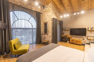 - une chambre avec un lit, une télévision et une chaise dans l'établissement Villa Sintica, à Sandanski