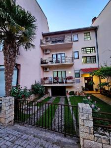 un edificio de apartamentos con una palmera y una valla en VN APARTMENTS OHRID, en Ohrid