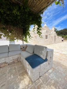 un sofá de piedra sentado en un patio en TrullidiGiulia Ostuni, en Ostuni