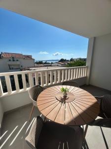 a table and chairs on a balcony with a view at Apartmani Andrea in Promajna
