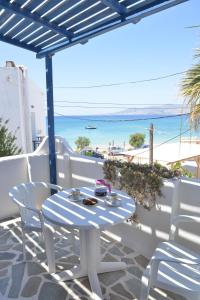 un tavolo e sedie su un balcone con vista sulla spiaggia di Plaza Studios ad Agia Anna Naxos