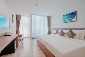 a hotel room with a large bed and a desk at Gosia Hotel in Nha Trang