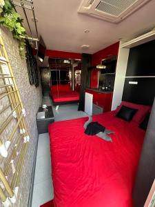um quarto com uma cama vermelha num quarto em AphrodiX em Cap d'Agde