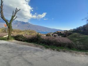a road with a view of a lake and a mountain at La Bella Garda in Tignale +4 photos