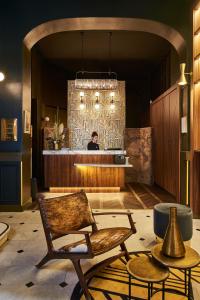 a man standing behind a counter in a lobby at Hotel Konti Bordeaux by HappyCulture in Bordeaux