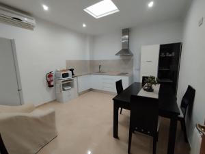 a kitchen with a black table and a black table and chairs at Mi Huella in Tomelloso