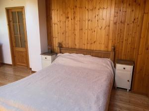 a bedroom with a bed with wooden walls and wooden floors at Casa OLMA in Aosta