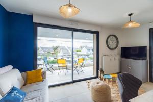 a living room with a couch and a table with chairs at Les terrasses de Ploumanac'h 150m de la plage in Perros-Guirec