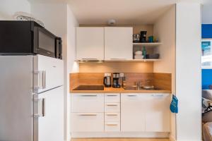 a kitchen with white cabinets and a sink at Les terrasses de Ploumanac'h 150m de la plage in Perros-Guirec
