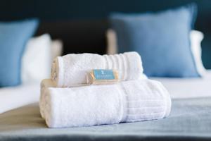 einen Haufen weißer Handtücher auf einem Bett in der Unterkunft Garden Route Ilita Lodge in Groot Brak Rivier