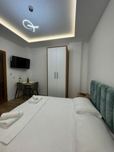 a bedroom with a large white bed and a table at VILA GOLDEN SAND in Ksamil