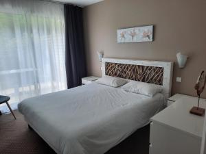 een slaapkamer met een groot wit bed en een raam bij Appartement AB DU PARC in Neufchâtel-Hardelot