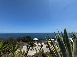un uomo che cammina lungo un marciapiede vicino all'oceano di R&B Santa Nicolella a Catania