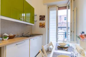a kitchen with a table and a green cabinet at Varese Centro - ViVa Apartment - Free WiFi in Varese