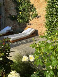 Relais Conac 1888 في Castelnuovo Don Bosco: سرير في وسط حديقة فيها ورد