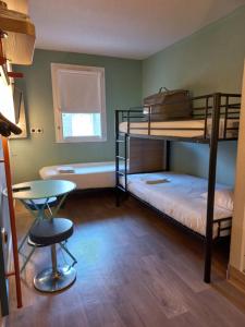 a room with bunk beds and a table and a chair at ibis budget Saint-Brieuc Yffiniac in Yffiniac