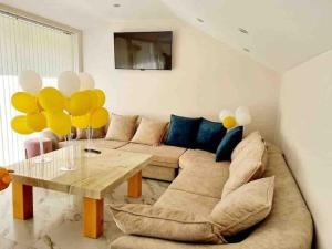 a living room with a couch and a table with yellow balloons at Boris House 5 bed Villa & Private Pool in Strumyani