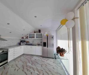a kitchen with a refrigerator and a table with a vase at Boris House 5 bed Villa & Private Pool in Strumyani