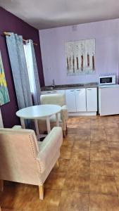 uma sala de estar com mesa e cadeiras e uma cozinha em Apartahotel portal de leon em Caboalles de Abajo