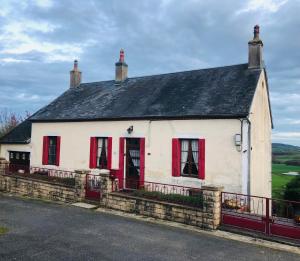 a white house with red windows and a black roof at Manoir BnBurgundy in Lanty
