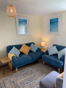 un soggiorno con 2 divani blu e un tappeto di Large 3 bedroom flat in Sennen a Penzance