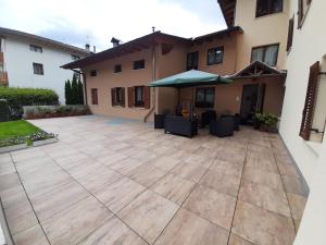 a patio in front of a house with an umbrella at Casa Viola in Cavedago +2 photos