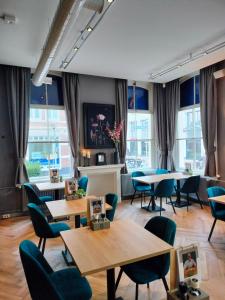 een restaurant met tafels, stoelen en ramen bij Het Oude Kantongerecht in Apeldoorn