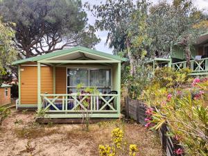 a small house with a porch in a garden at Camping la Croix du Sud in Saint-Tropez