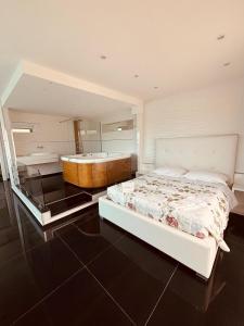 1 dormitorio con 1 cama grande y bañera en B&B Monti, en Porto Cesareo