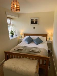 ein Schlafzimmer mit einem Bett mit zwei blauen Kissen in der Unterkunft Large 3 bedroom flat in Sennen in Penzance