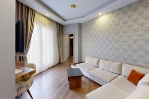伊斯坦堡的住宿－King City Hotel，客厅配有白色的沙发和桌子