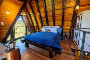 Un dormitorio con una cama en una habitación con paredes de madera. en Sítio Mar de Nuvens Chalés Morro da Igreja, Urubici, SC., en Urubici