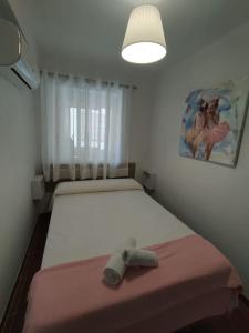 a bedroom with two beds and a pink blanket at Apartamento Diputación 25 in Nerja