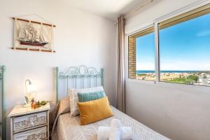 um pequeno quarto com uma cama e uma janela em Bonito Piso a 1 minuto de la Playa em La Antilla
