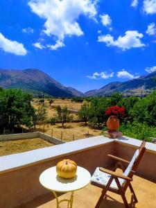 a table and a chair on a balcony with a view at villa archontiko ASKYFOU SFAKIA in Karés